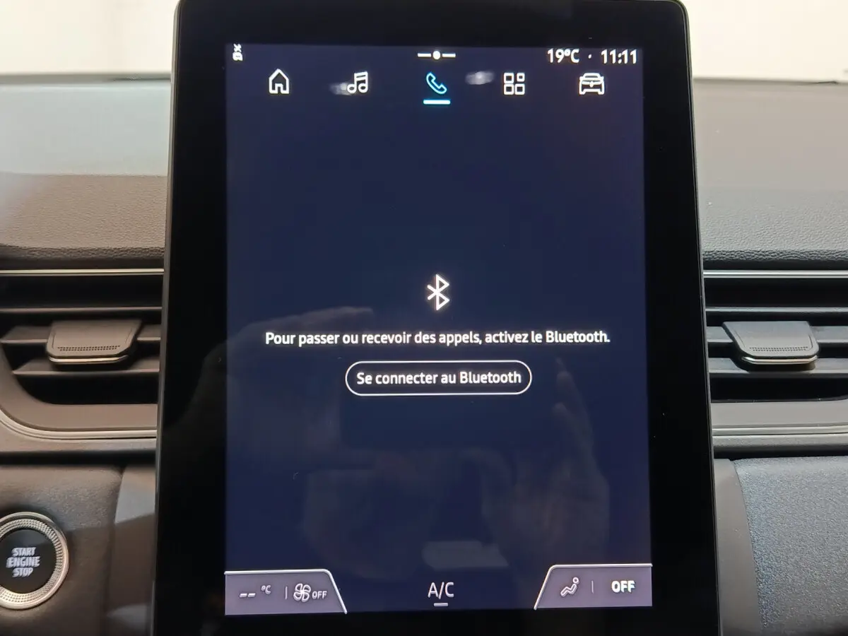 Écran tactile central affichant la connexion Bluetooth dans l’habitacle du Renault Captur blanc techno E-Tech 2025.
