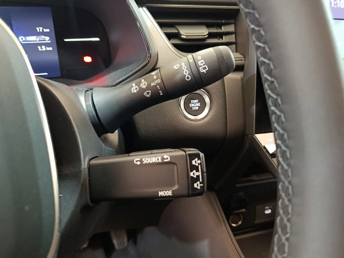 Détail intérieur du volant et commandes avec bouton start/stop du Renault Captur blanc techno E-Tech 2025.