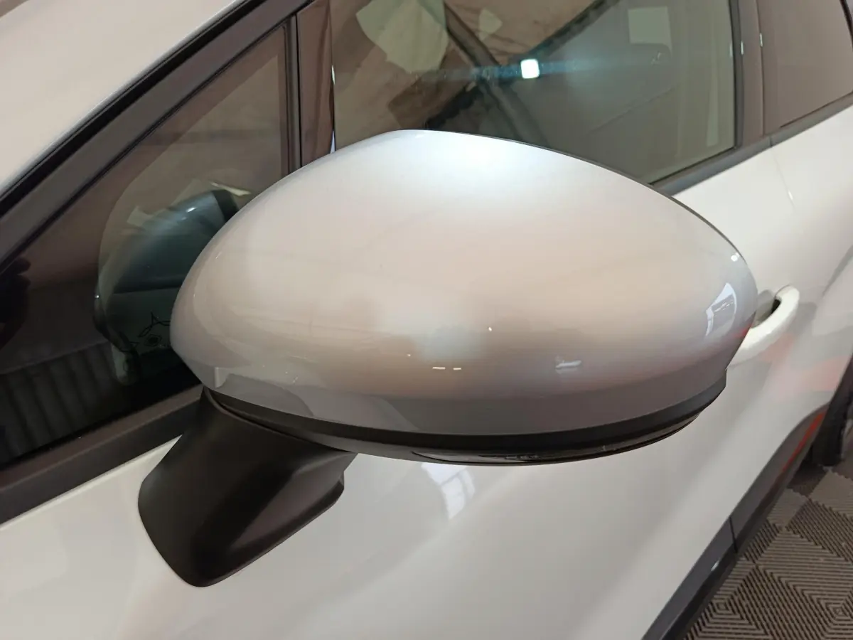 Rétroviseur droit blanc brillant du Renault Captur 2025 techno E-Tech full hybrid, avec clignotant intégré visible.