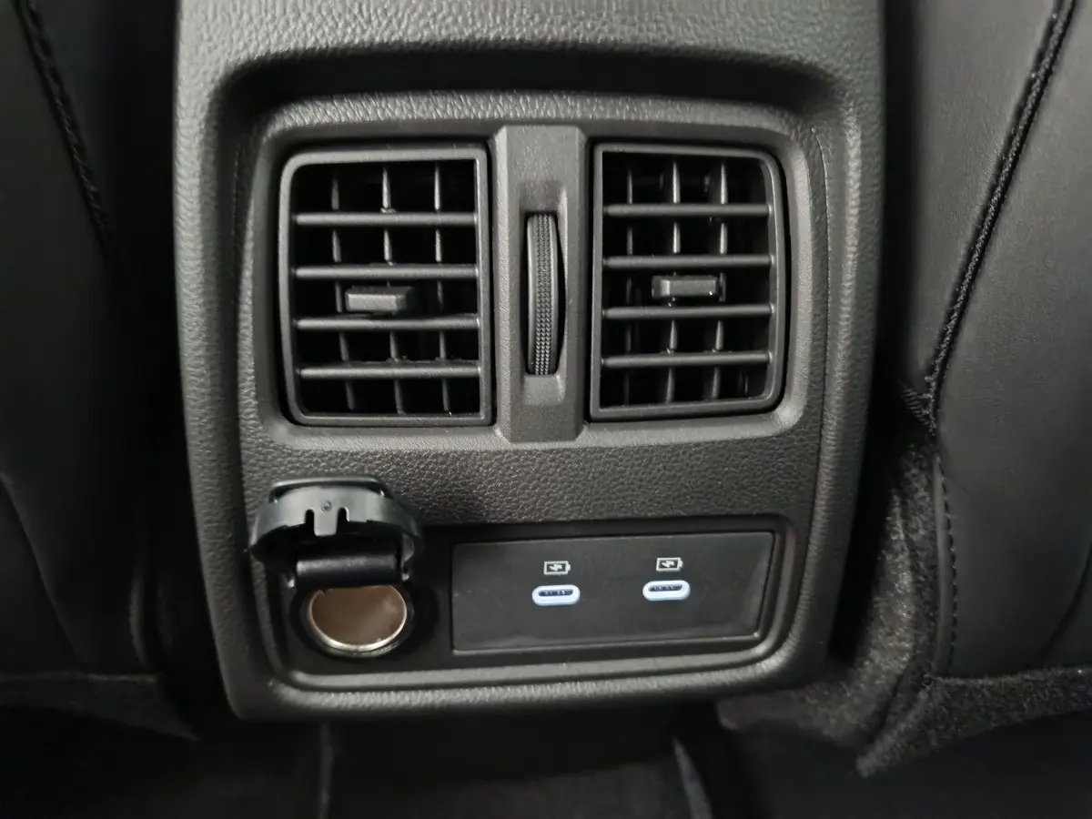 Prise USB et prise 12V sous les aérateurs arrière noirs du Renault Captur blanc, vue intérieure arrière centrale.