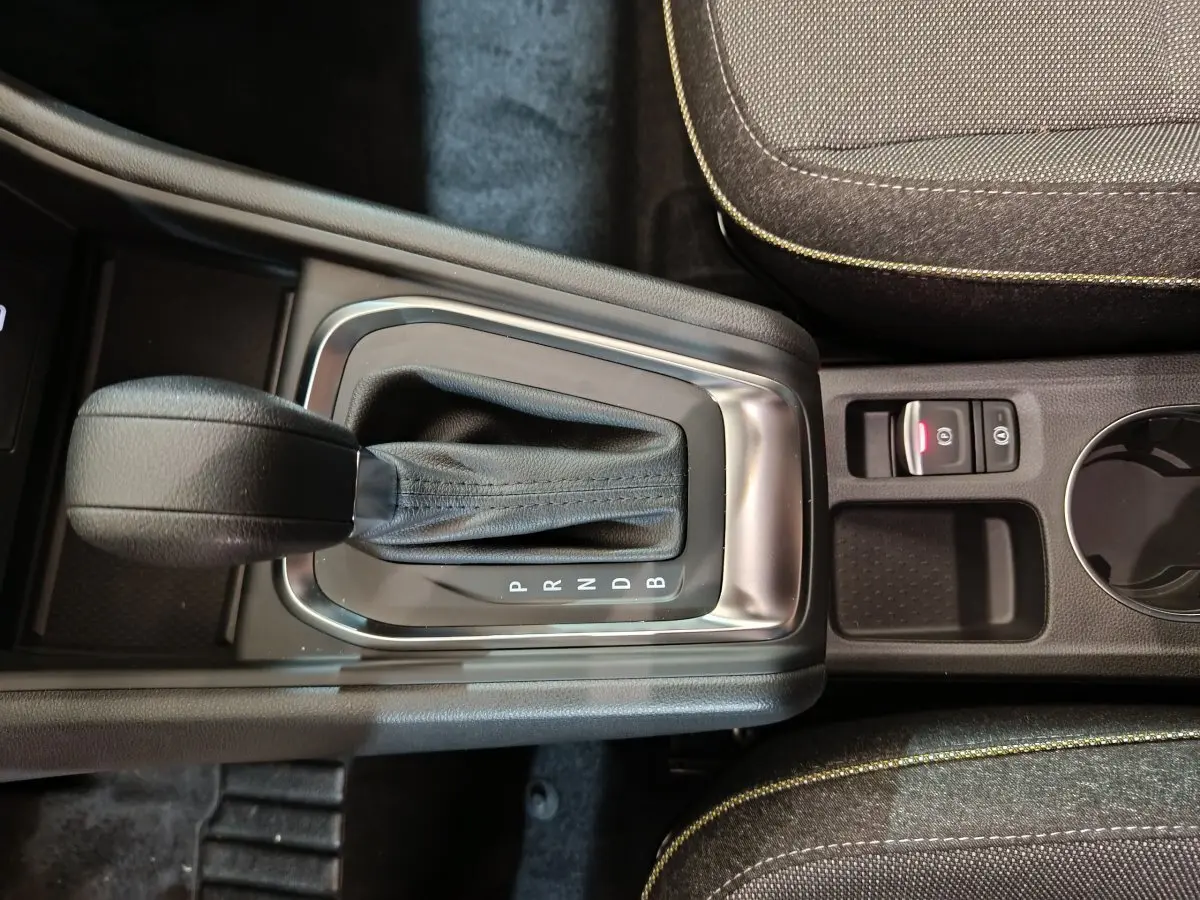 Vue rapprochée de la boîte automatique noire et du frein à main électrique dans l'habitacle du Renault Captur blanc 2025.