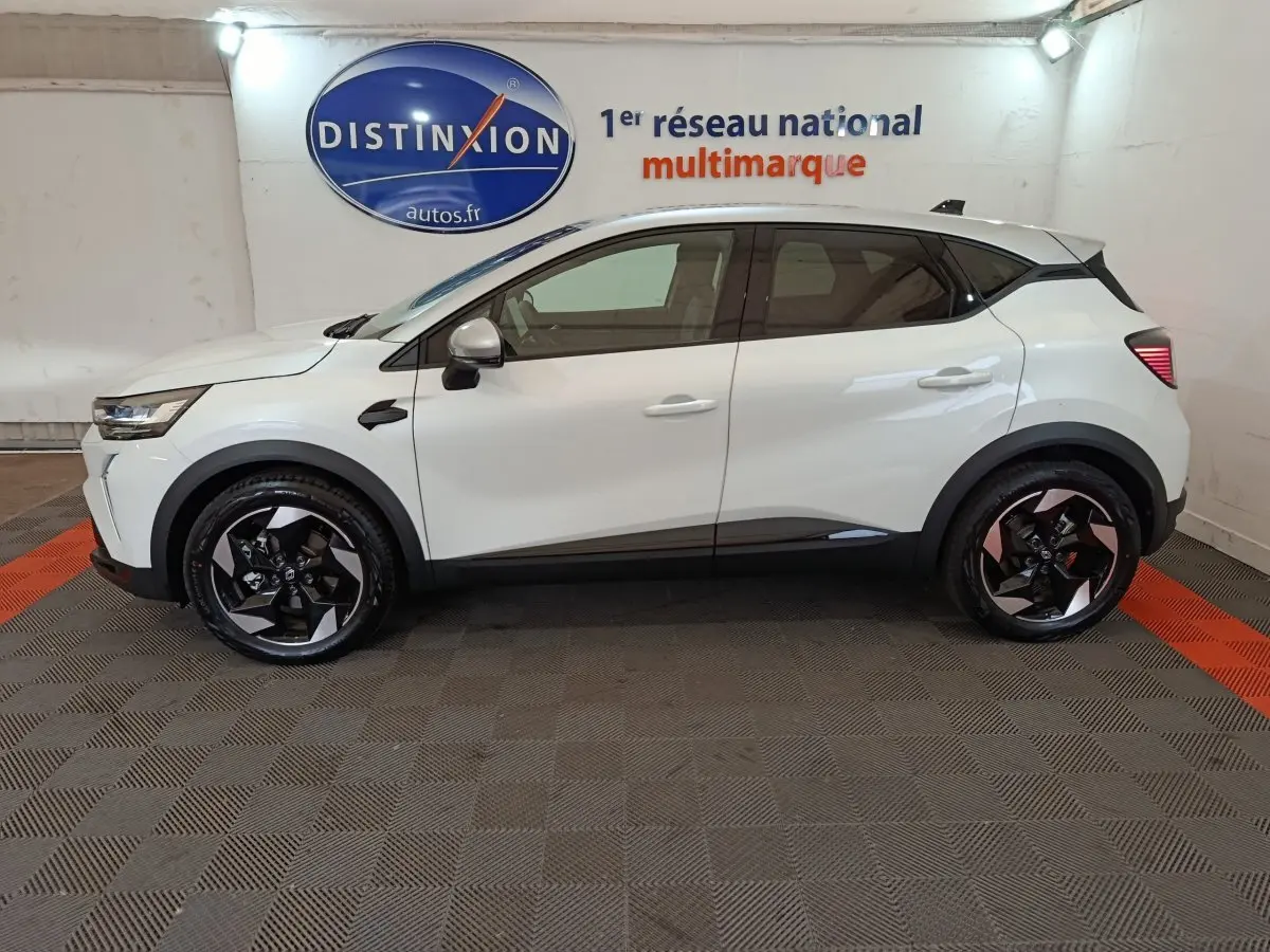 Profil côté gauche d'un Renault Captur blanc 2025 techno E-Tech full hybrid avec jantes noires et toit noir.