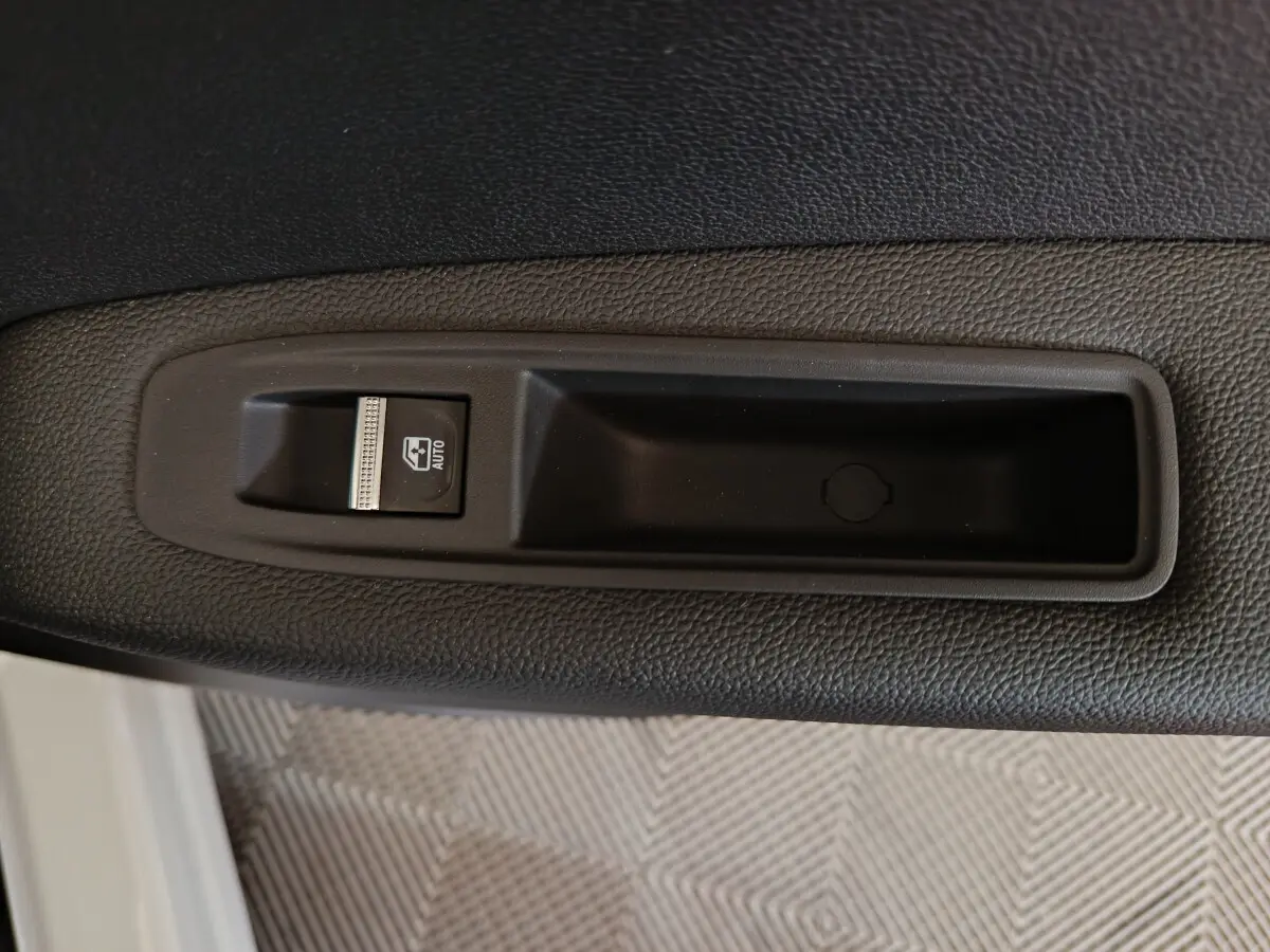 Gros plan sur le bouton de commande de vitre électrique côté conducteur du Renault Captur blanc 2025.