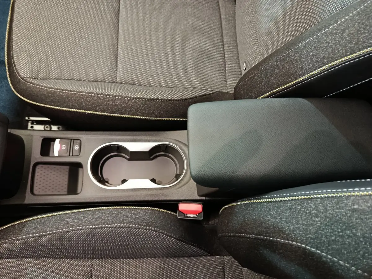 Vue plongeante sur la console centrale noire et les sièges gris foncé avec surpiqûres jaunes du Renault Captur blanc 2025.