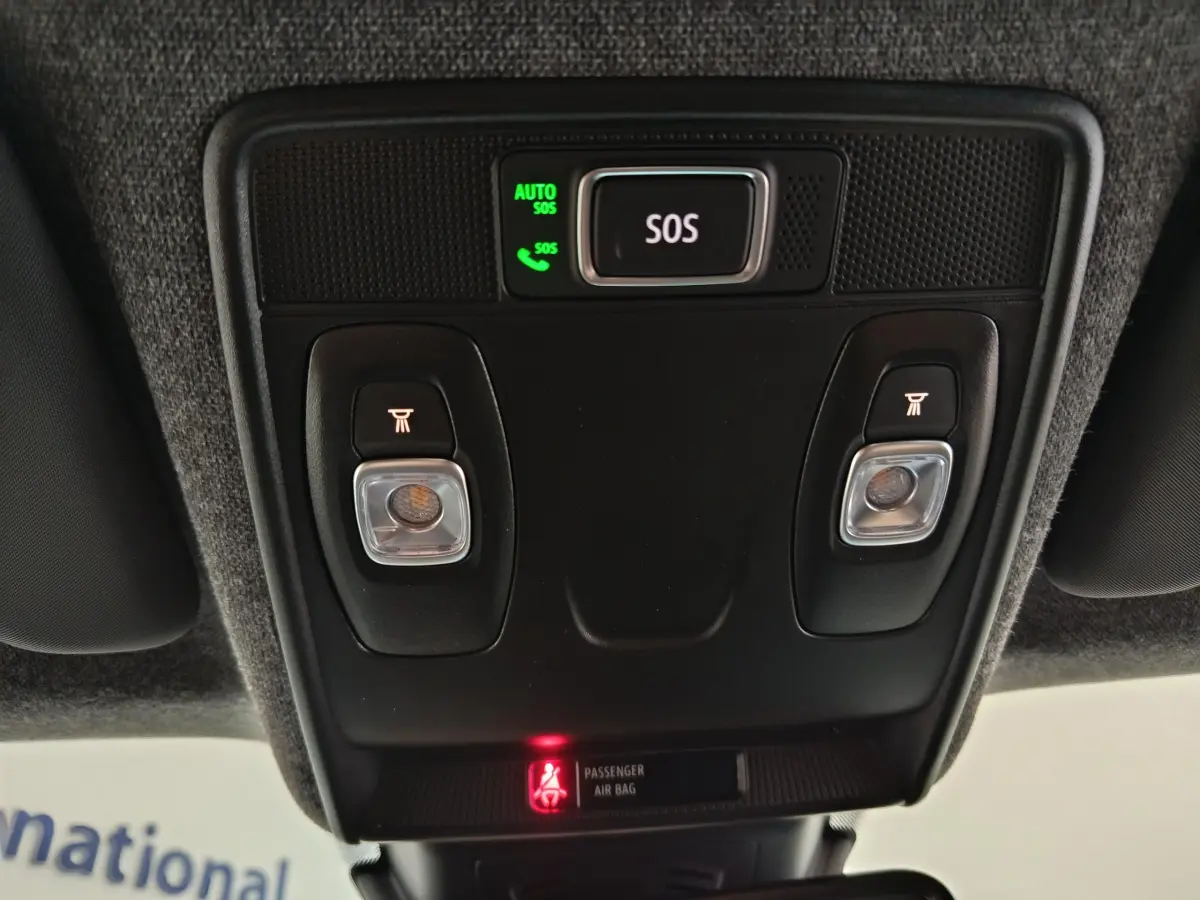 Vue en contre-plongée du panneau de commande de toit noir avec bouton SOS et éclairages intérieurs dans un Renault Captur blanc 2025.