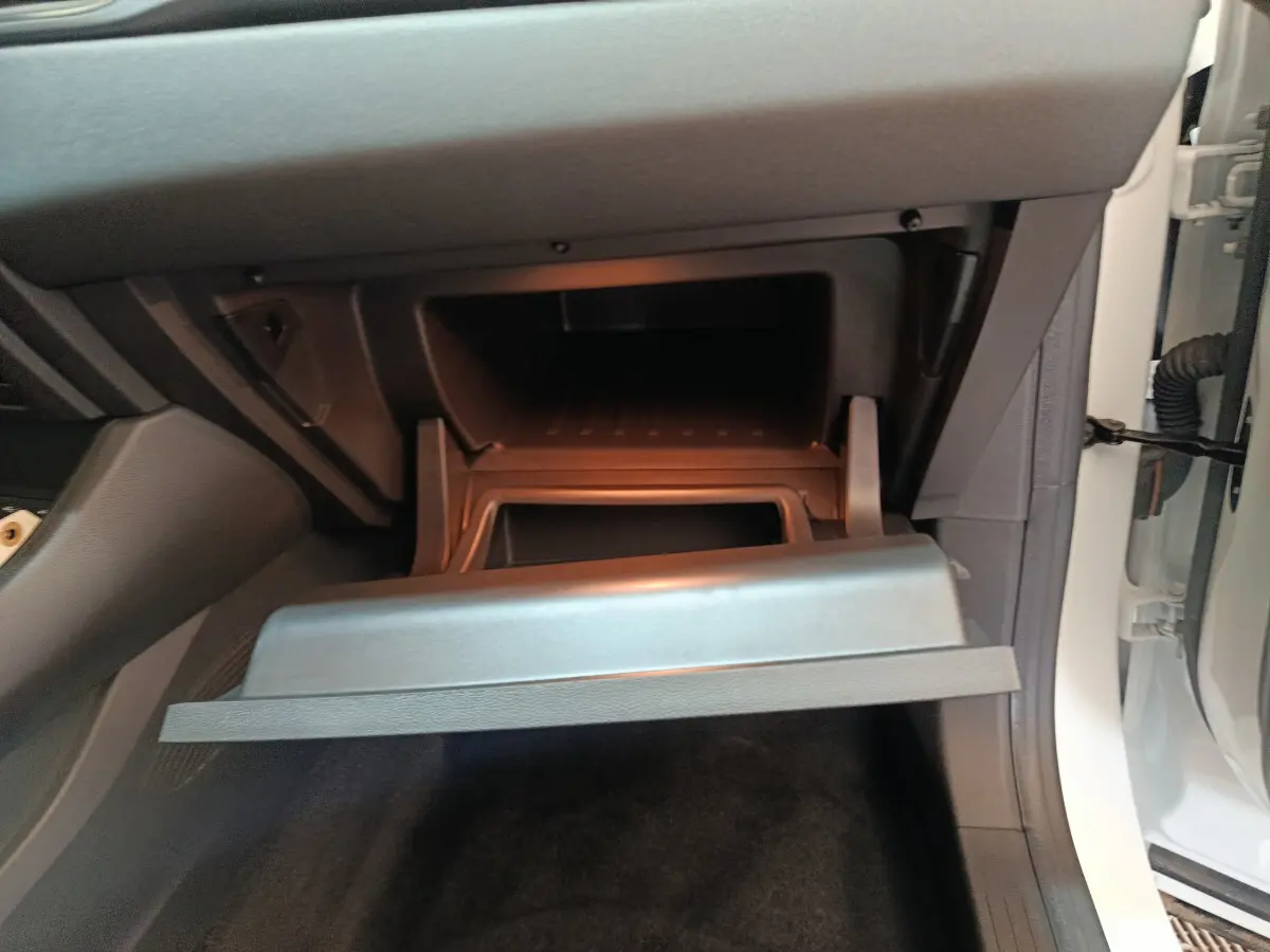 Vue intérieure côté passager du coffre à gants ouvert d'un Renault Captur blanc 2025 techno E-Tech full hybrid.