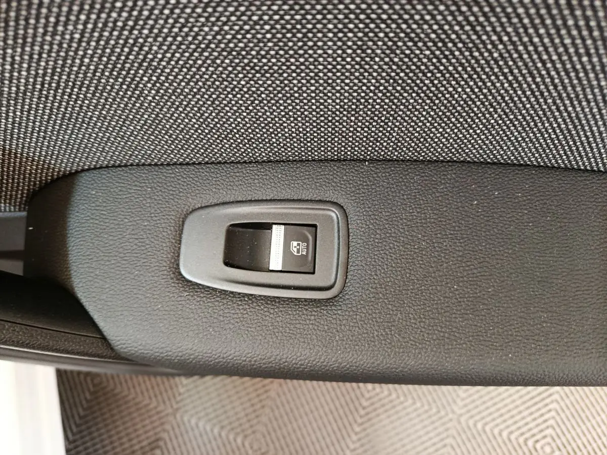 Bouton de commande de lève-vitre électrique sur la portière intérieure d'un Renault Captur blanc 2025.