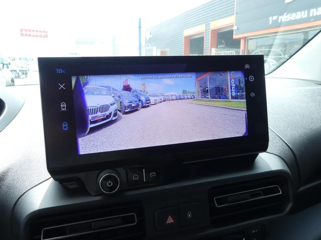 Écran tactile intérieur du Peugeot Partner XL affichant la caméra de recul avec vue sur un parking extérieur.