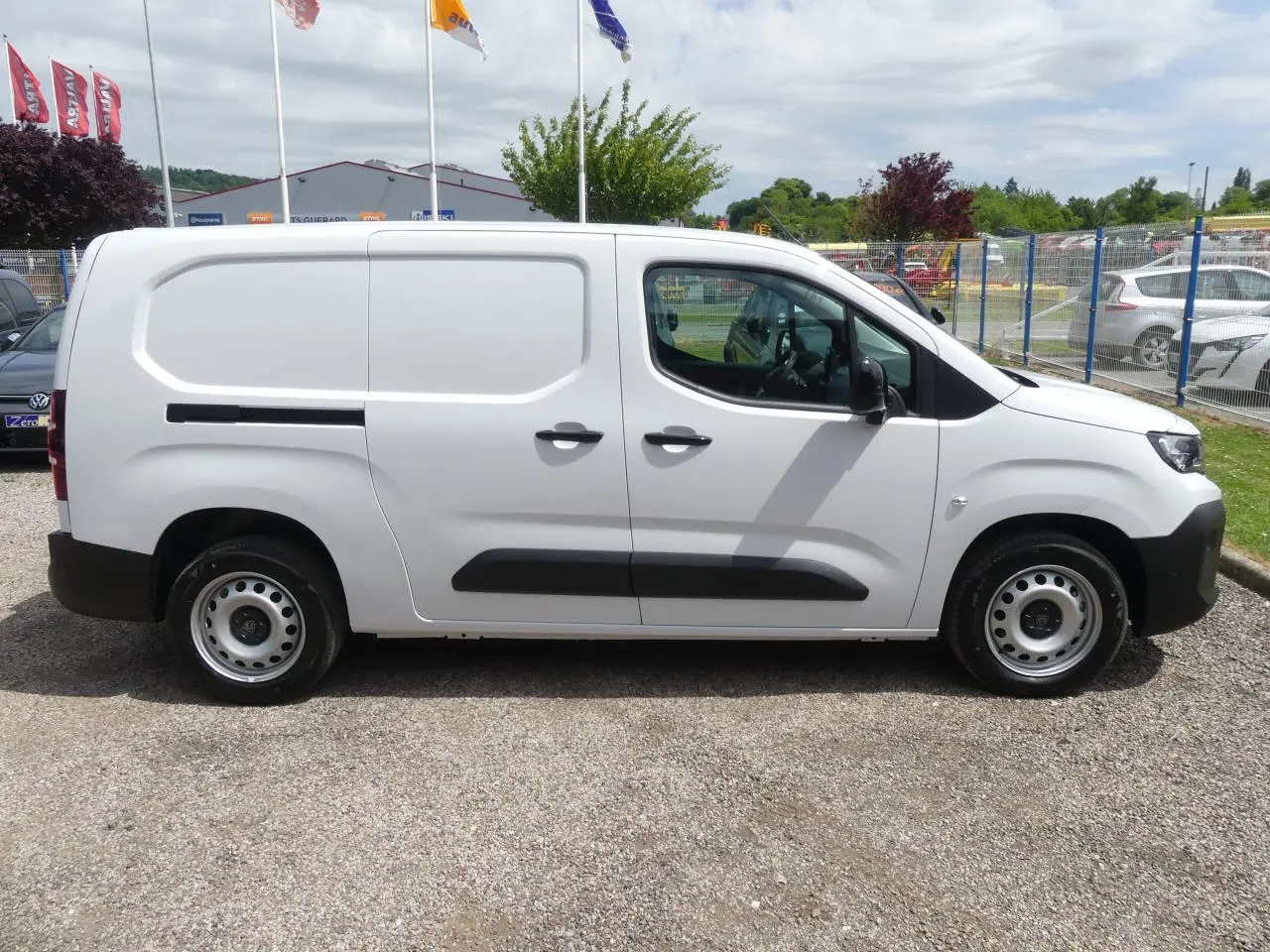 Peugeot Partner blanc vu de profil côté gauche, fourgon utilitaire avec portes coulissantes et jantes tôles.