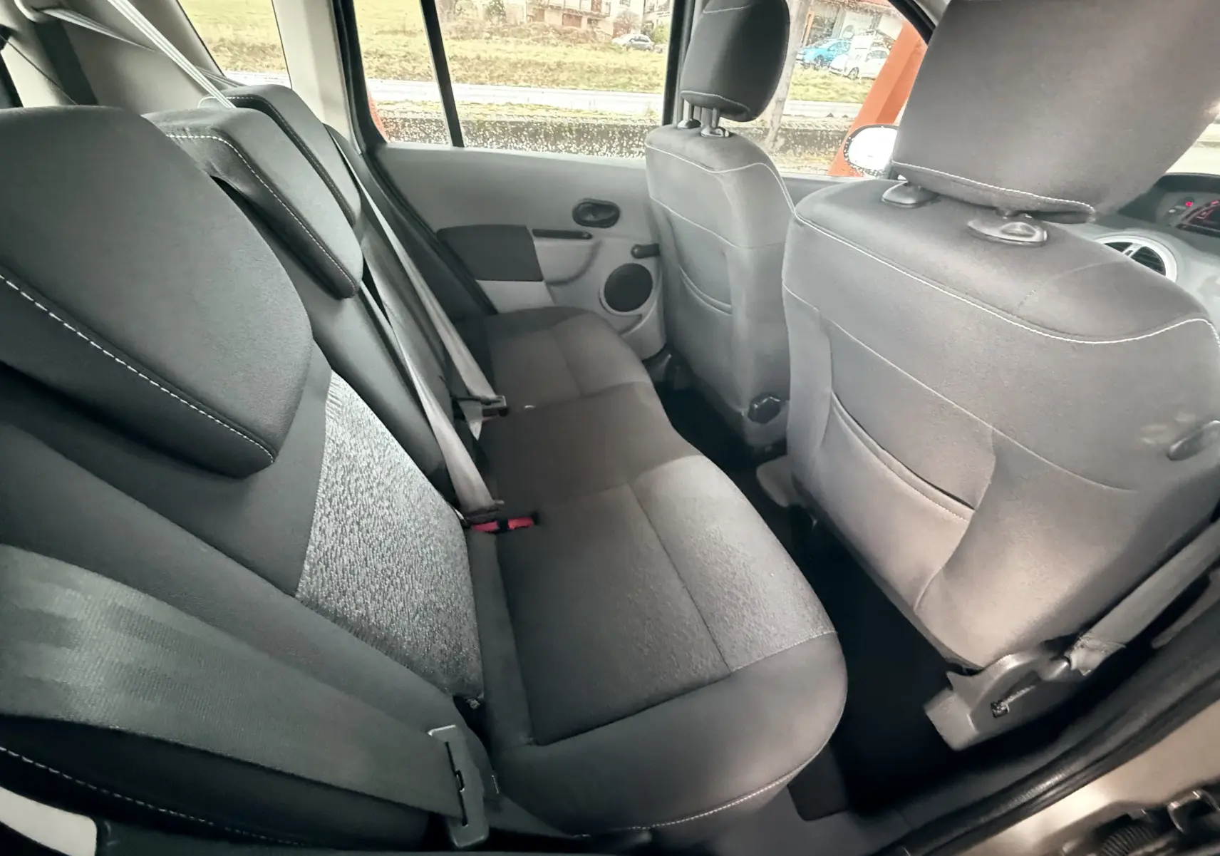 Vue intérieure montrant les sièges arrière en tissu gris noir de la Renault Modus beige, côté droit ouvert.