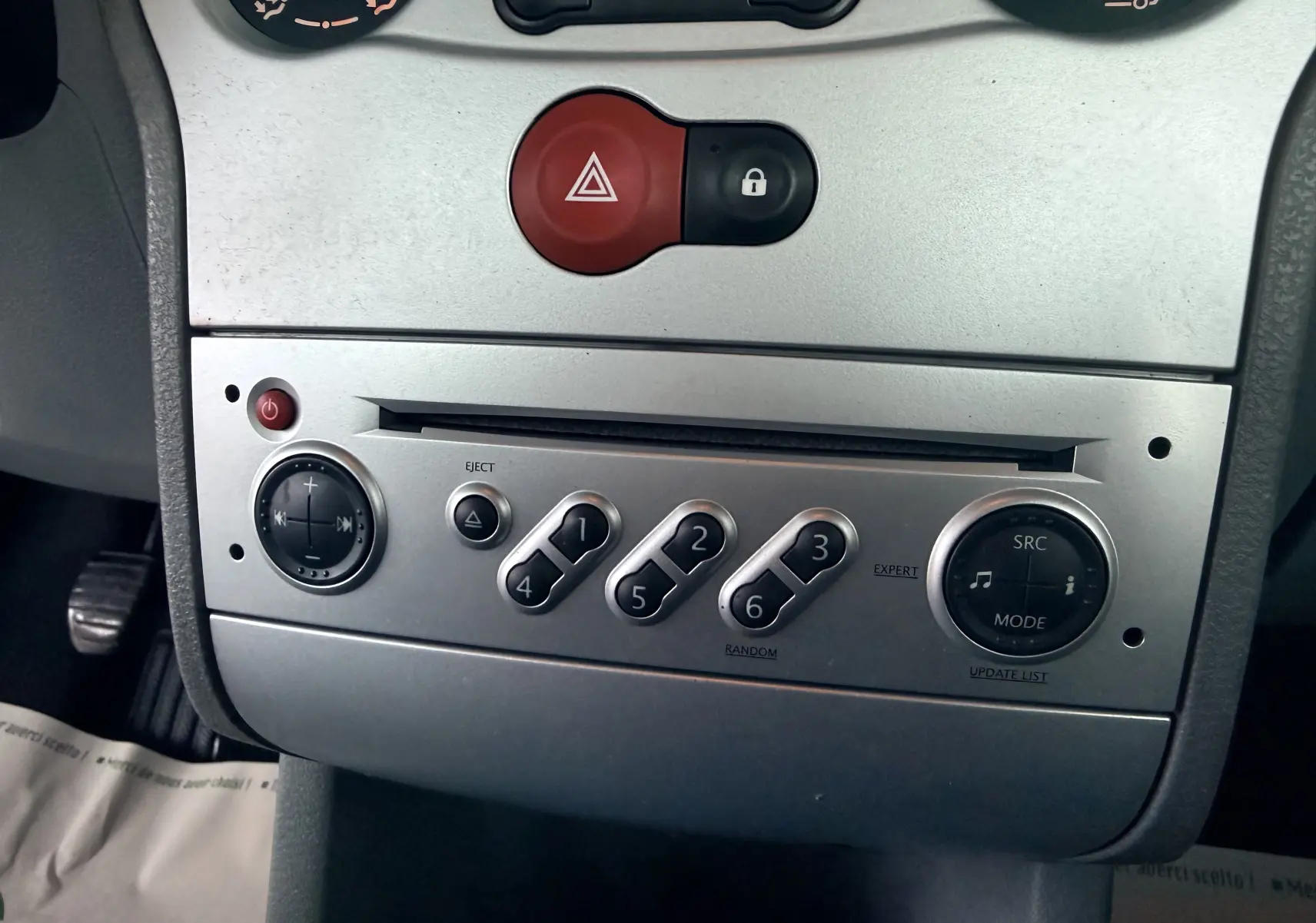 Vue rapprochée de la console centrale argentée du Renault Modus 2011, avec boutons de commande audio et alerte.