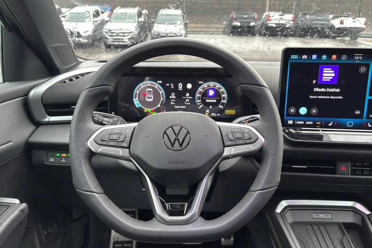 Vue intérieure centrée sur le volant cuir multifonctions du Volkswagen T-Roc 2026 avec écran digital et tableau de bord numérique.