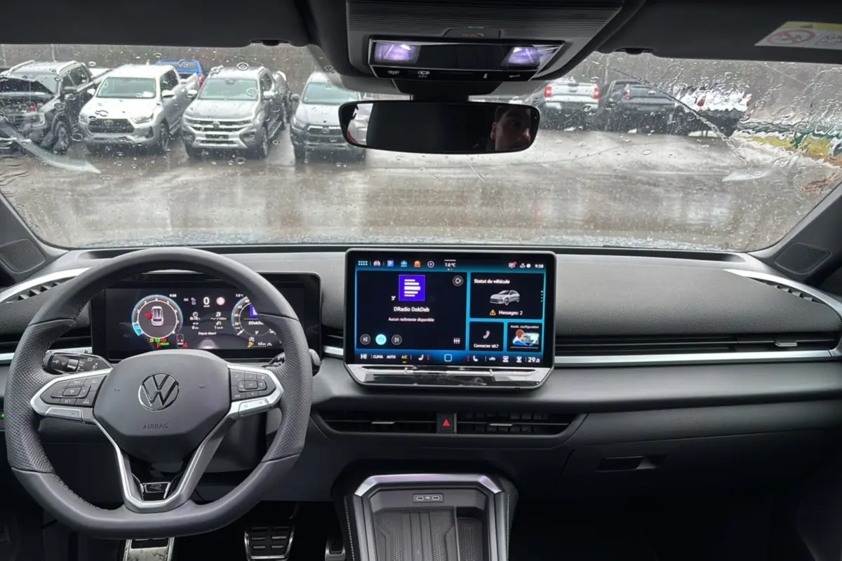 Vue intérieure du tableau de bord du Volkswagen T-Roc gris loup, avec écran tactile central et volant multifonctions.