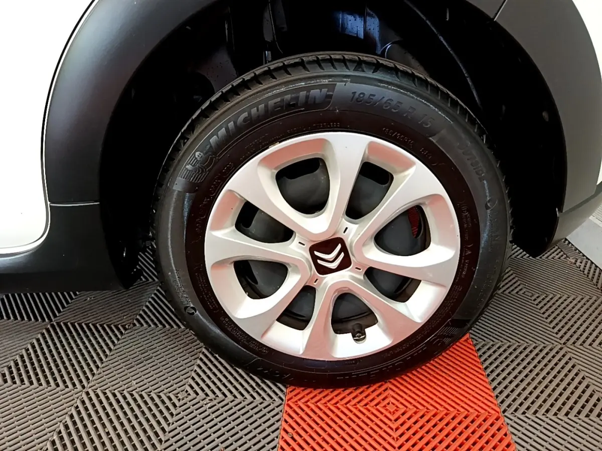 Gros plan sur la roue avant gauche blanche d'une Citroën C3 avec jante en alliage et pneu Michelin.