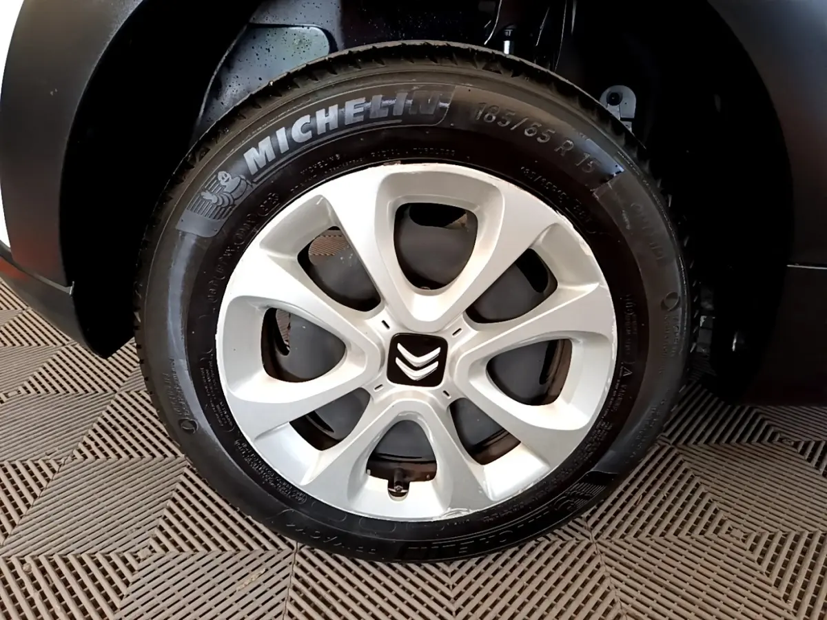 Gros plan sur la roue avant gauche d'une Citroën C3 blanche, avec jante alliage et pneu Michelin visible.