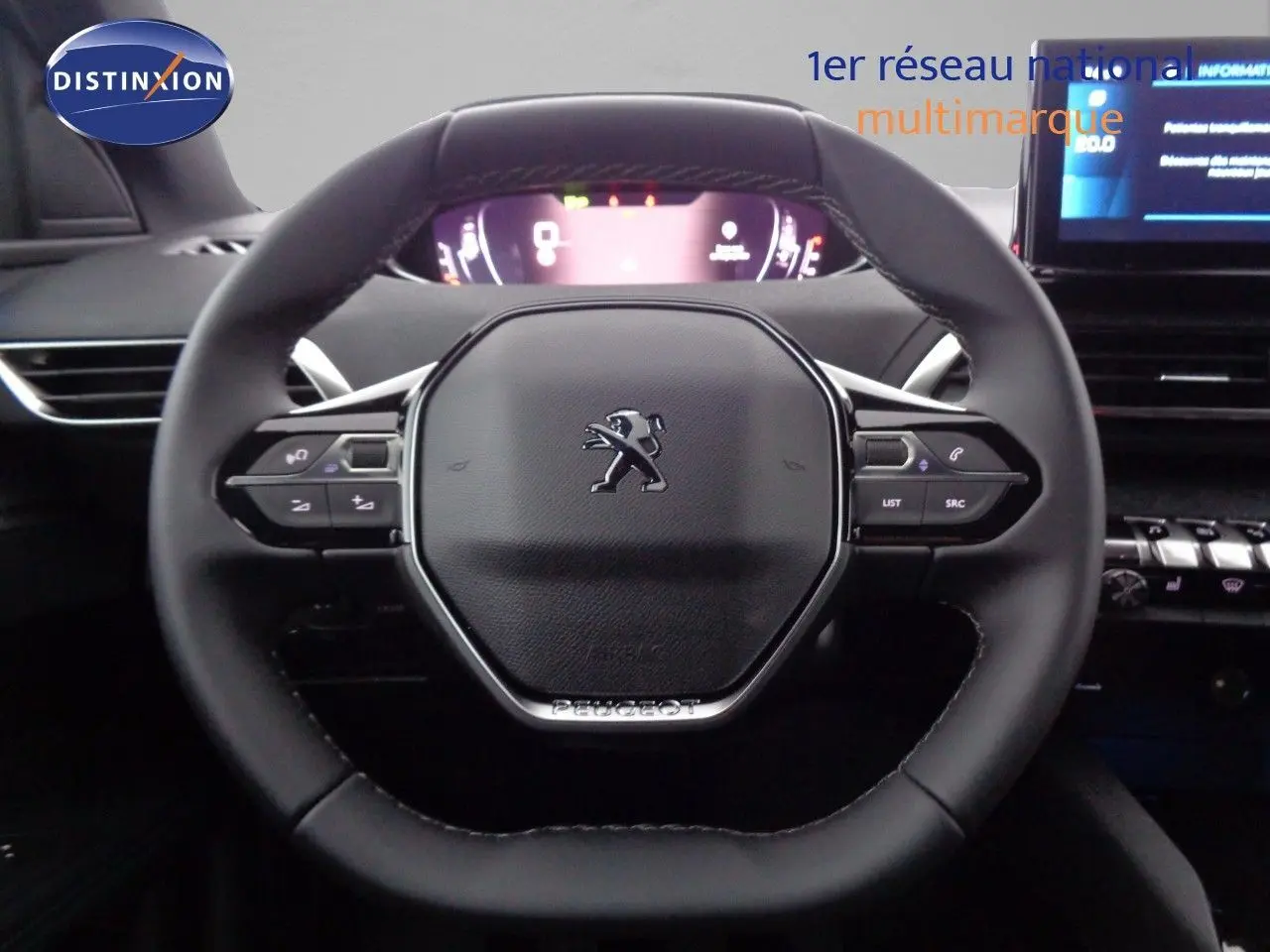 Volant cuir Peugeot 3008 2023 avec commandes intégrées, tableau de bord numérique et écran tactile visible en arrière-plan.