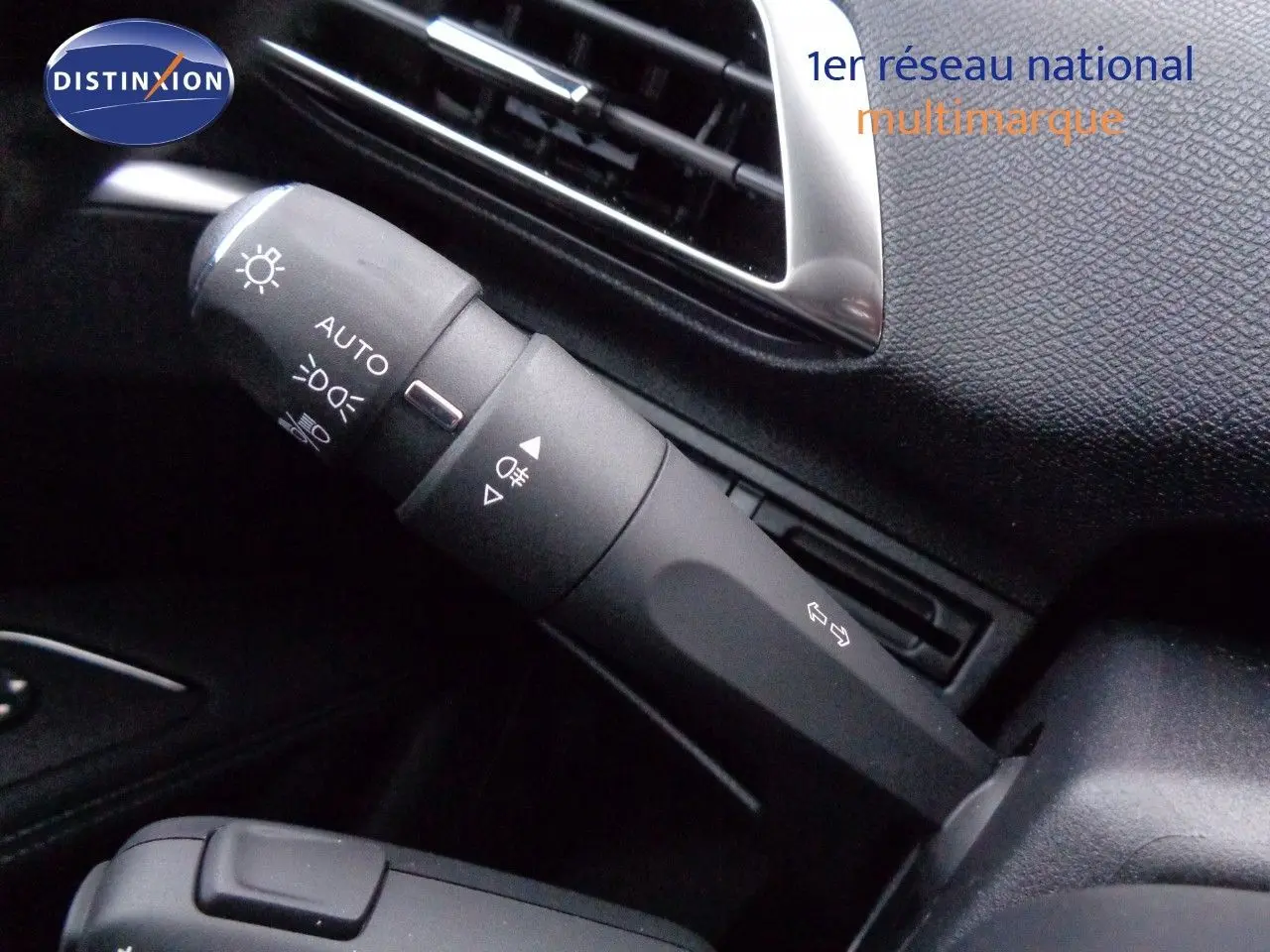 Gros plan sur la commande des feux et clignotants dans l'habitacle noir du Peugeot 3008 2023.