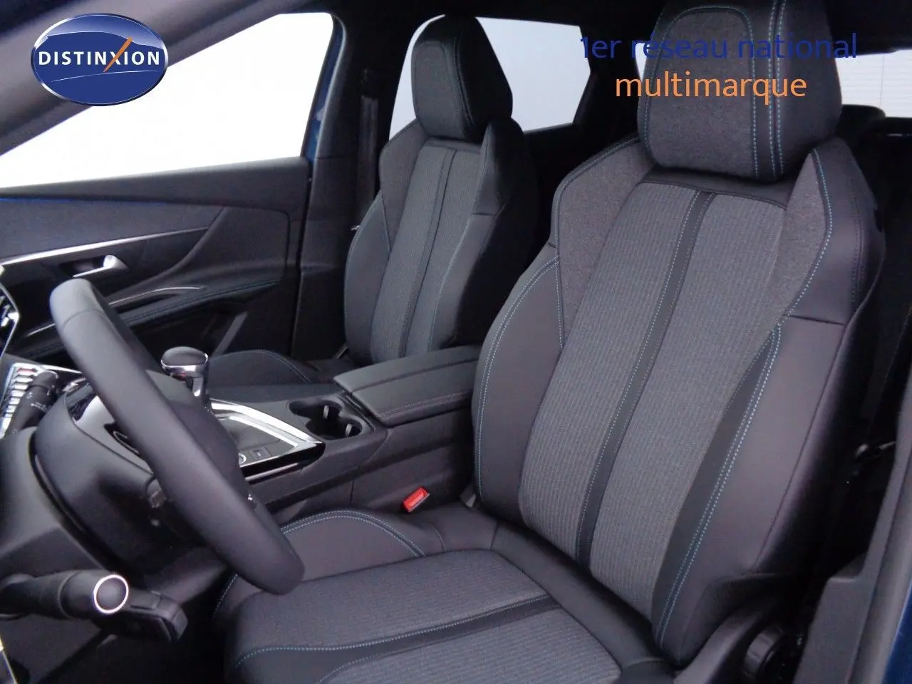 Vue intérieure côté conducteur du Peugeot 3008 2023, sièges tissu et cuir noir avec surpiqûres bleues.