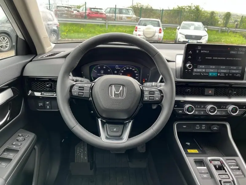 Vue intérieure du tableau de bord du Honda CR-V 2024 avec volant cuir multifonction et écran tactile central.