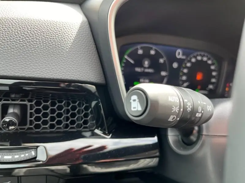 Gros plan sur la commande des phares et clignotants du tableau de bord du Honda CR-V 2024 blanc nacré.