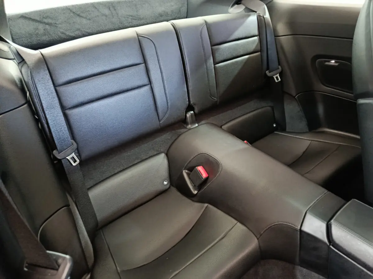 Vue rapprochée de la banquette arrière en cuir noir de la Porsche 911 Carrera 4S Coupé 2019, avec ceintures visibles.