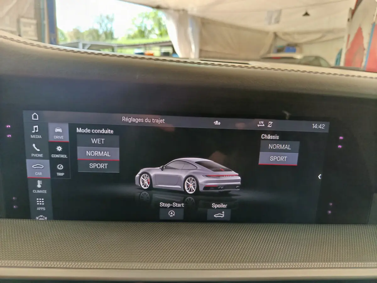 Écran tactile intérieur affichant une Porsche 911 Carrera 4S Coupé gris foncé en vue 3/4 arrière.