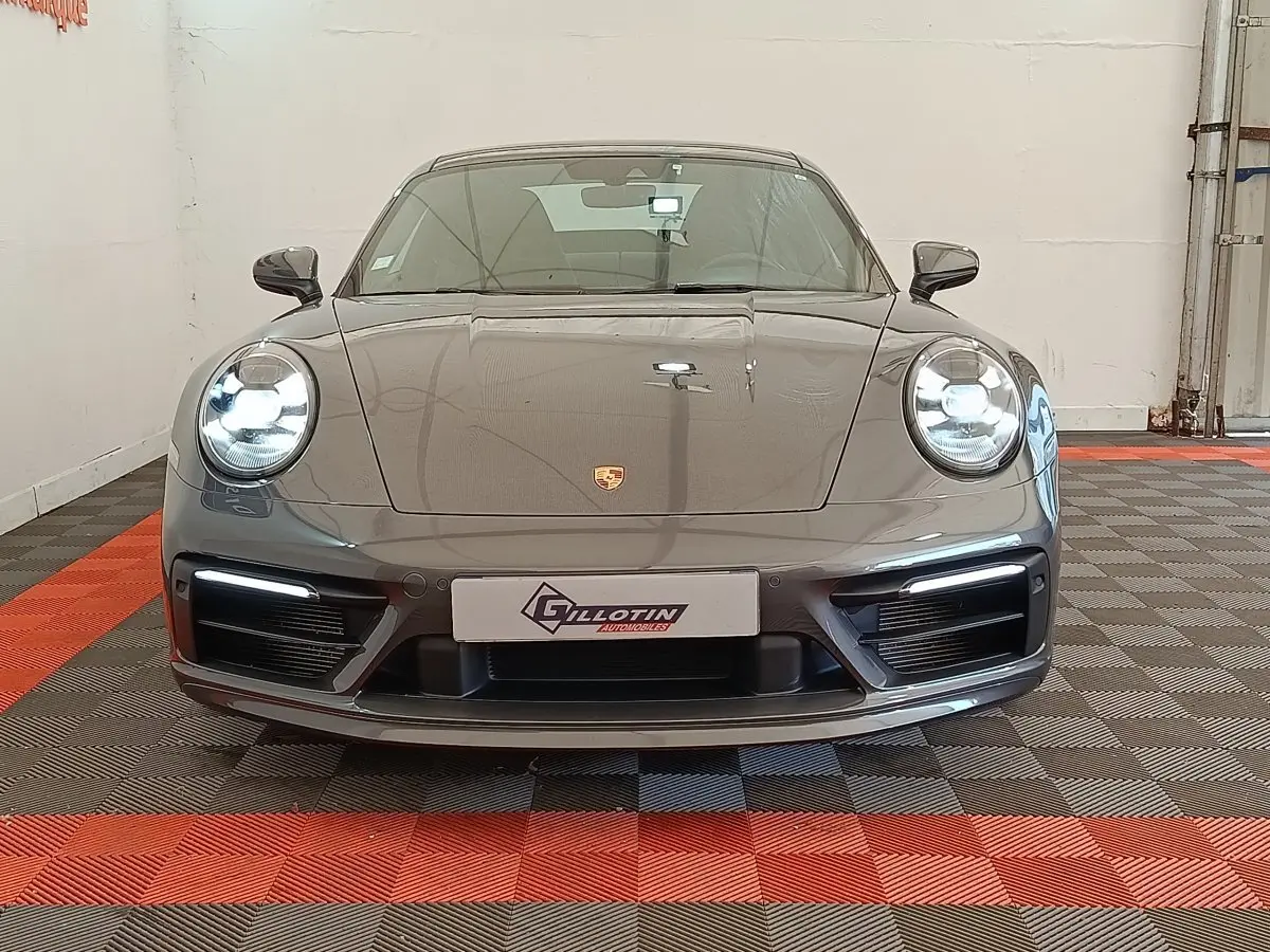 Vue frontale d'une Porsche 911 Carrera 4S Coupé gris foncé avec phares LED allumés et plaque d'immatriculation Gilotin.