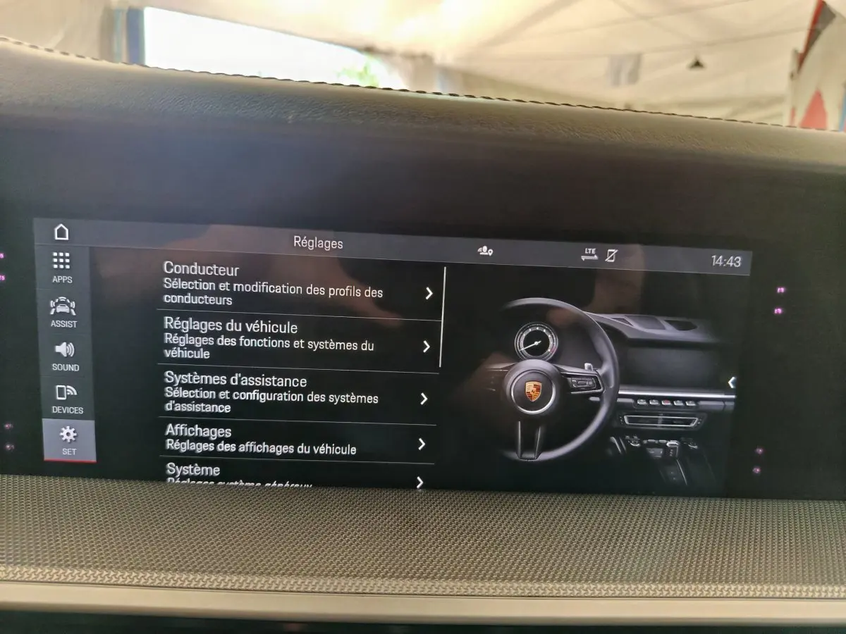 Écran tactile central affichant les réglages du véhicule dans l'habitacle d'une Porsche 911 Carrera 4S Coupé gris foncé.