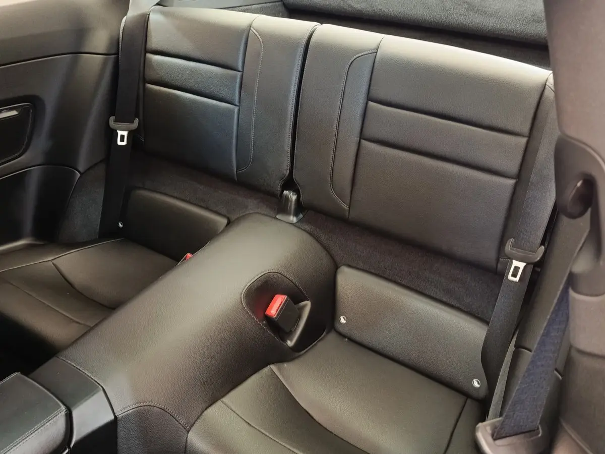 Vue rapprochée des sièges arrière en cuir noir de la Porsche 911 Carrera 4S Coupé 2019, avec ceintures de sécurité visibles.