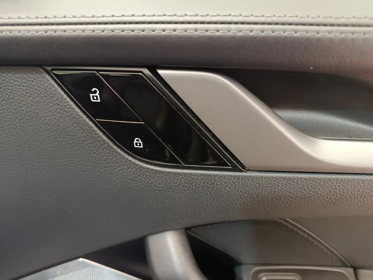 Gros plan sur la commande de verrouillage des portes côté conducteur, garniture cuir noire de la Porsche 911 Carrera 4S 2019.