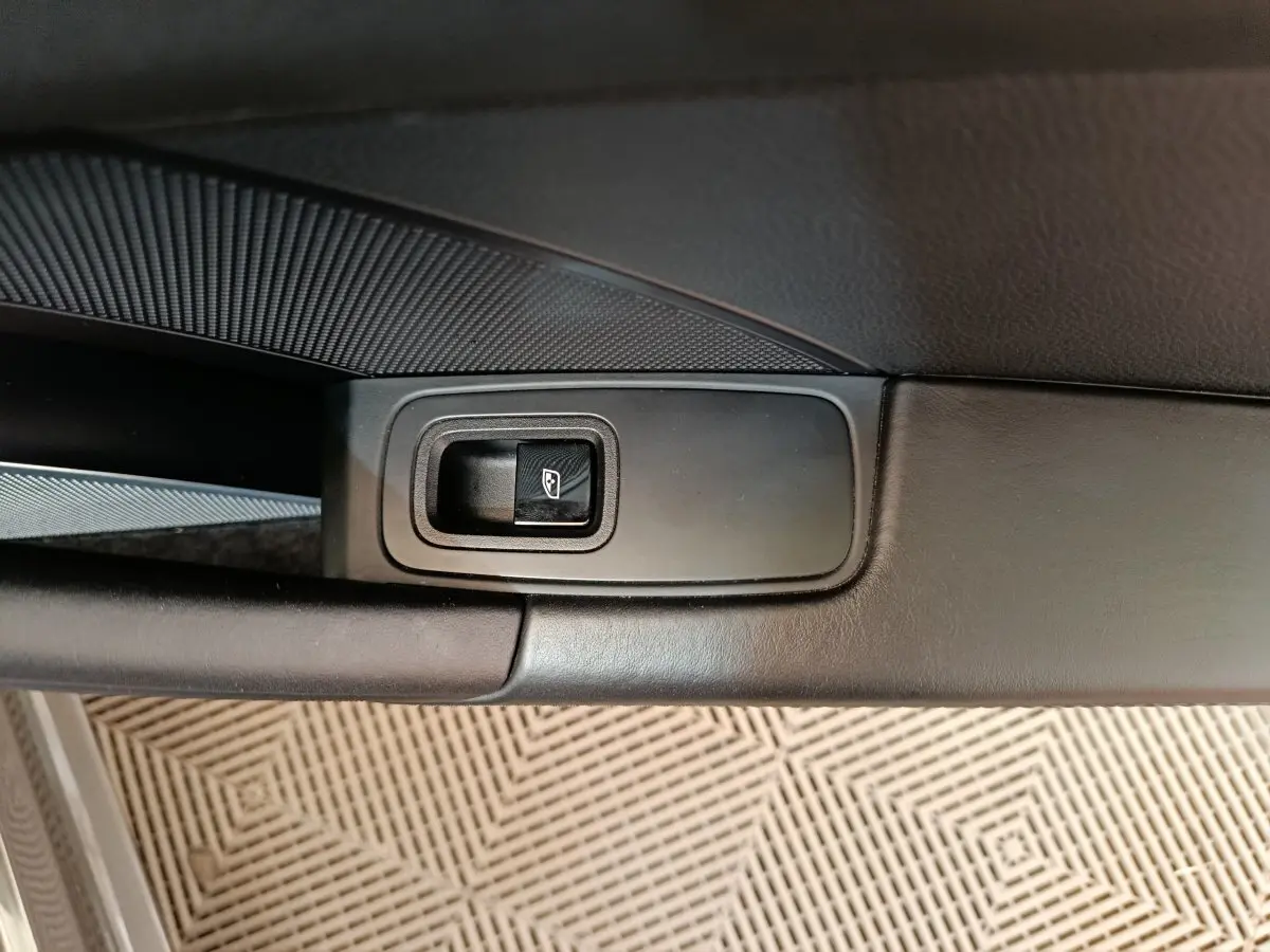 Gros plan sur le bouton de lève-vitre électrique côté gauche de la porte intérieure noire d'une Porsche 911 Carrera 4S Coupé 2019.