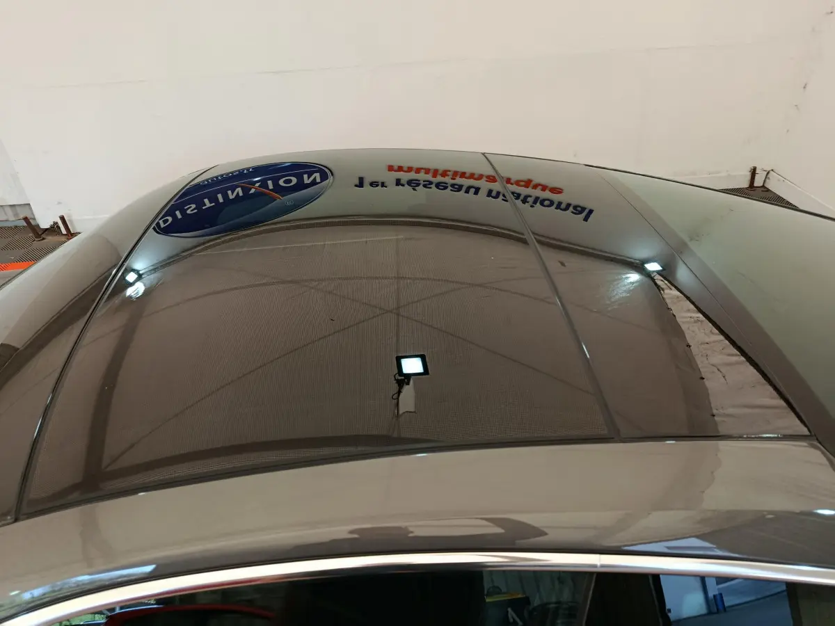 Toit panoramique en verre du Porsche 911 Carrera 4S Coupé gris foncé, vue plongeante sur l'habitacle et le reflet du plafond.