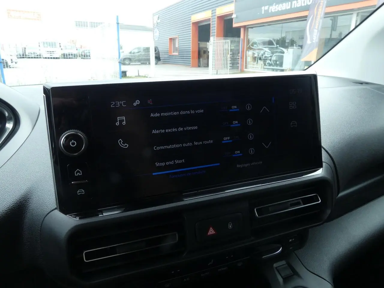 Écran tactile 10 pouces du tableau de bord du Peugeot Partner blanc, affichant les aides à la conduite.