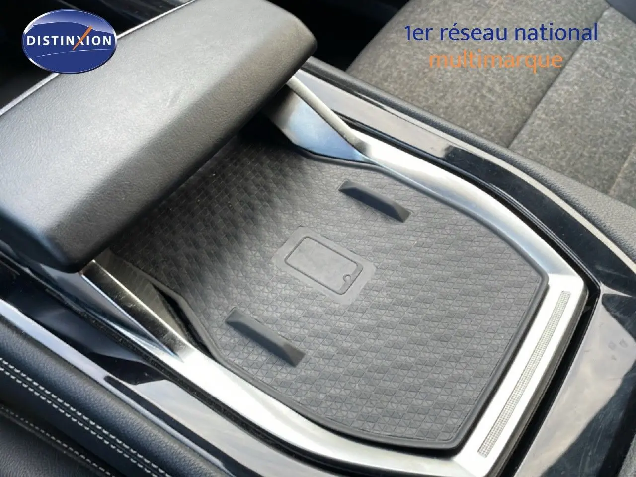 Détail de la console centrale avec chargeur sans fil et accoudoir en cuir noir du Renault Espace VI hybride 2024.