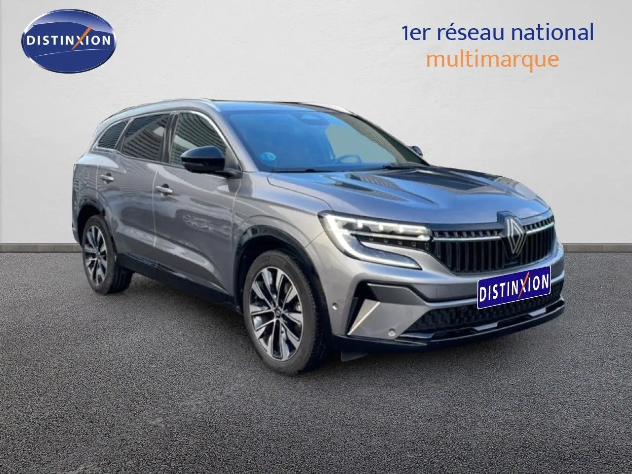 Renault Espace VI gris schiste métal en 3/4 avant droit, SUV hybride avec calandre distinctive et jantes alliage.