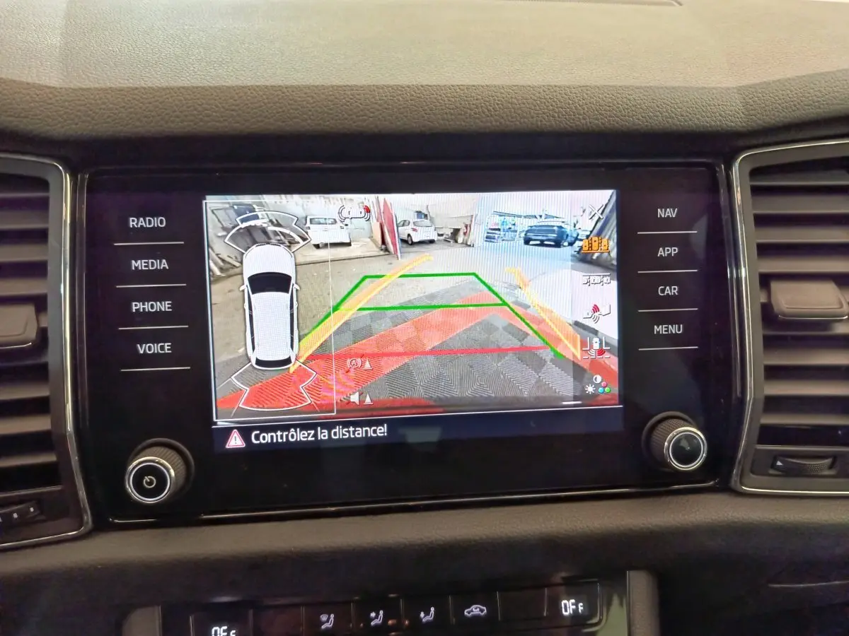 Écran tactile central du Skoda Kodiaq noir 2021 montrant la caméra de recul avec alertes de distance en couleur.