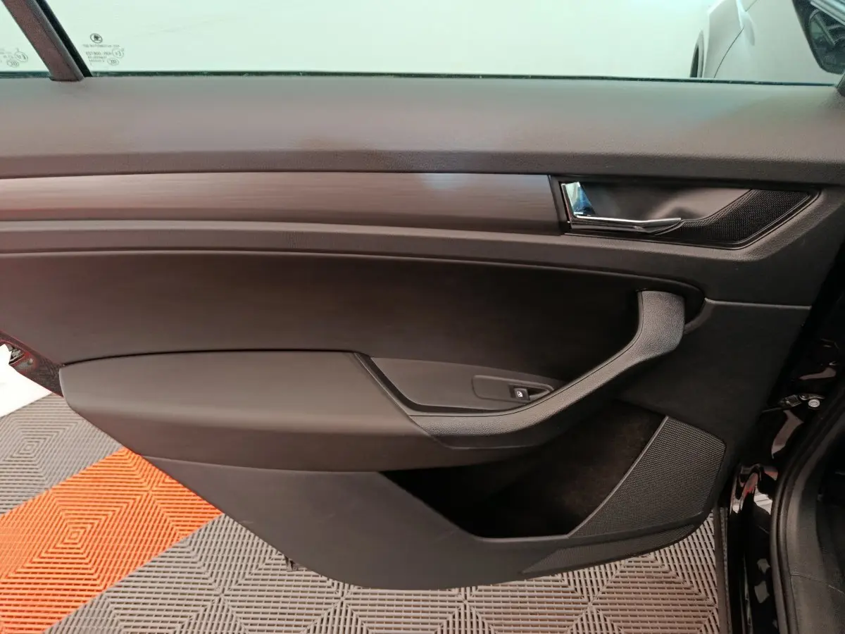 Porte intérieure côté gauche noire du Skoda Kodiaq 2021, avec poignée argentée et commande de lève-vitre.