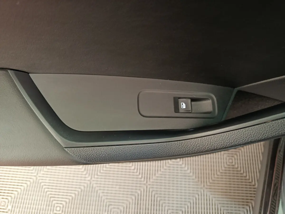 Détail de la commande de verrouillage des portes sur la portière intérieure côté droit d’un Skoda Kodiaq noir.