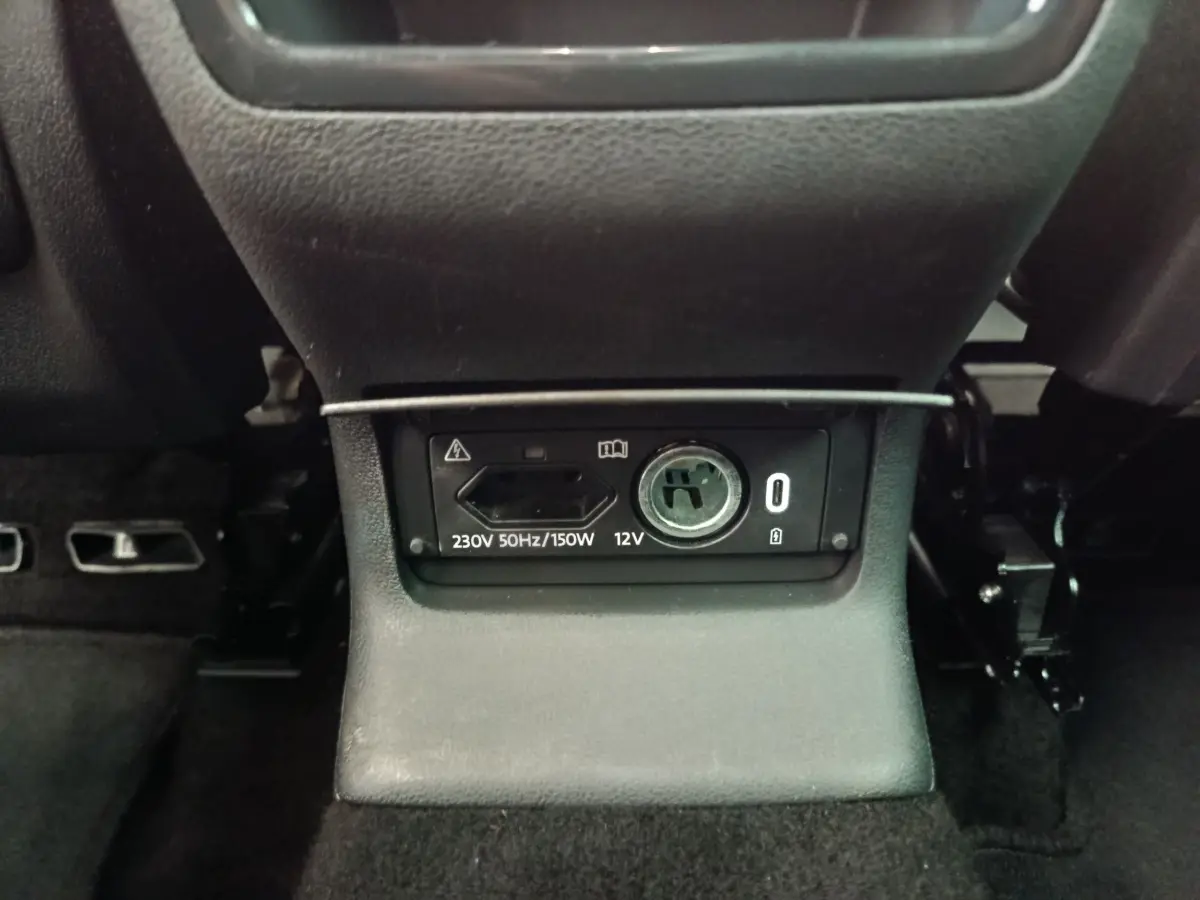 Prise 230V et 12V en gros plan sous la console centrale arrière du Skoda Kodiaq noir 2021.