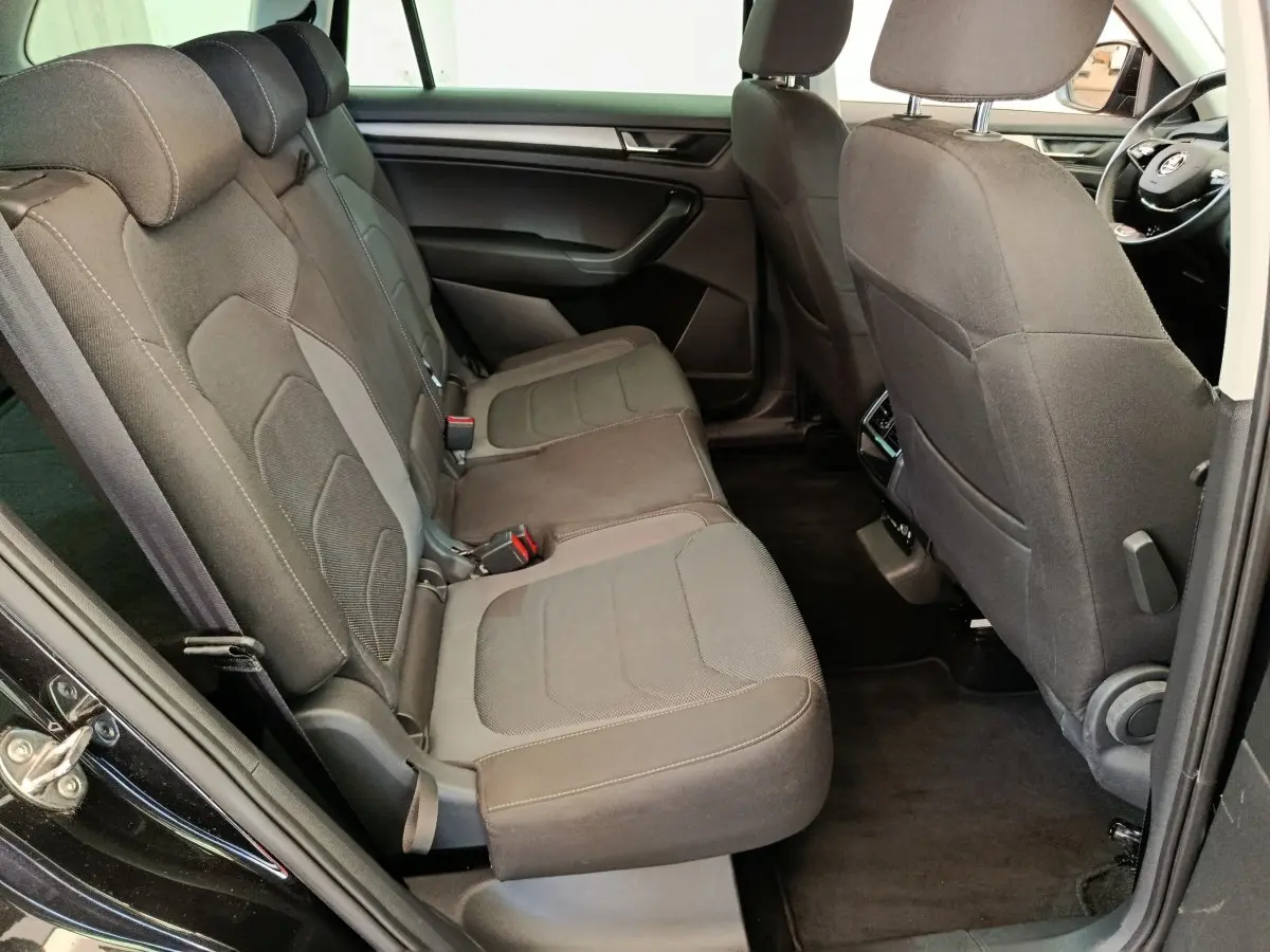 Vue côté gauche de l'habitacle arrière noir du Skoda Kodiaq 2021 avec banquette tissu et sièges individuels à l'avant.