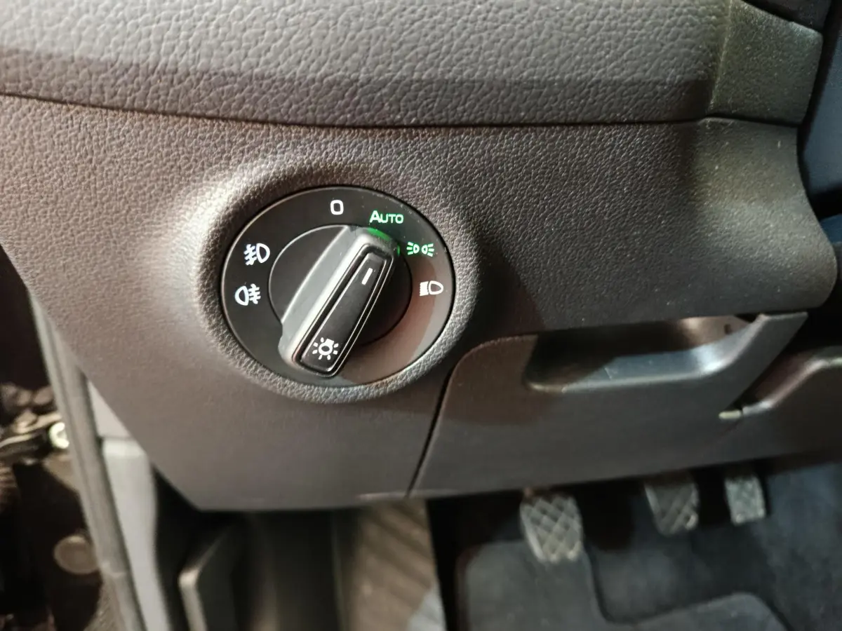 Gros plan sur le bouton de commande des phares en mode automatique dans l'habitacle noir du Skoda Kodiaq noir 2021.