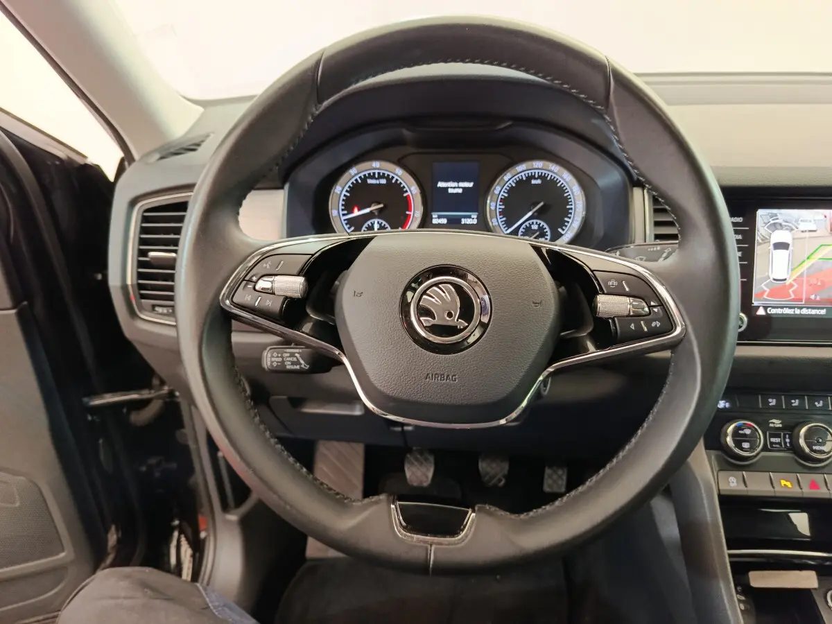 Vue rapprochée du volant cuir noir de la Skoda Kodiaq 2021 avec tableau de bord et écran tactile affichant la caméra de recul.