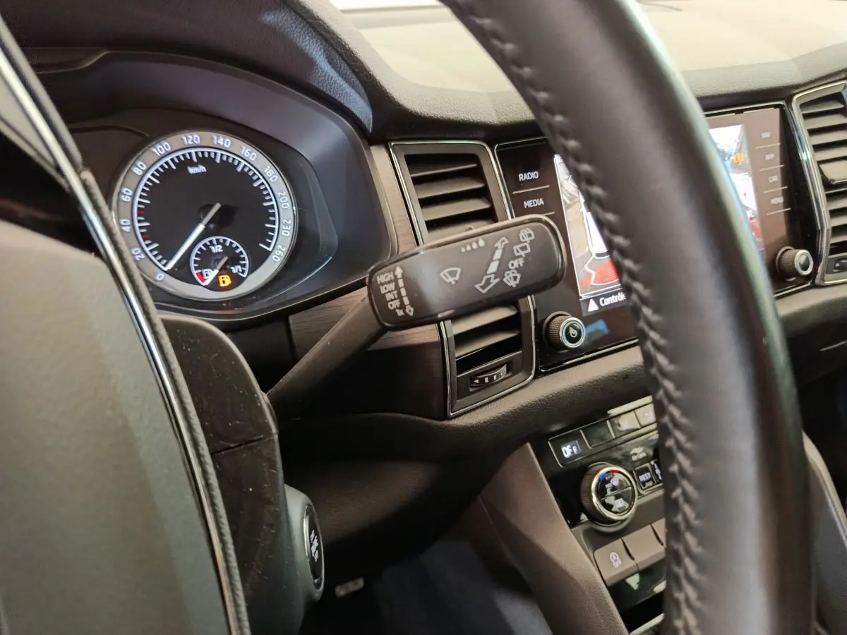 Intérieur du Skoda Kodiaq noir 2021, vue rapprochée du tableau de bord côté conducteur avec commandes et écran tactile.