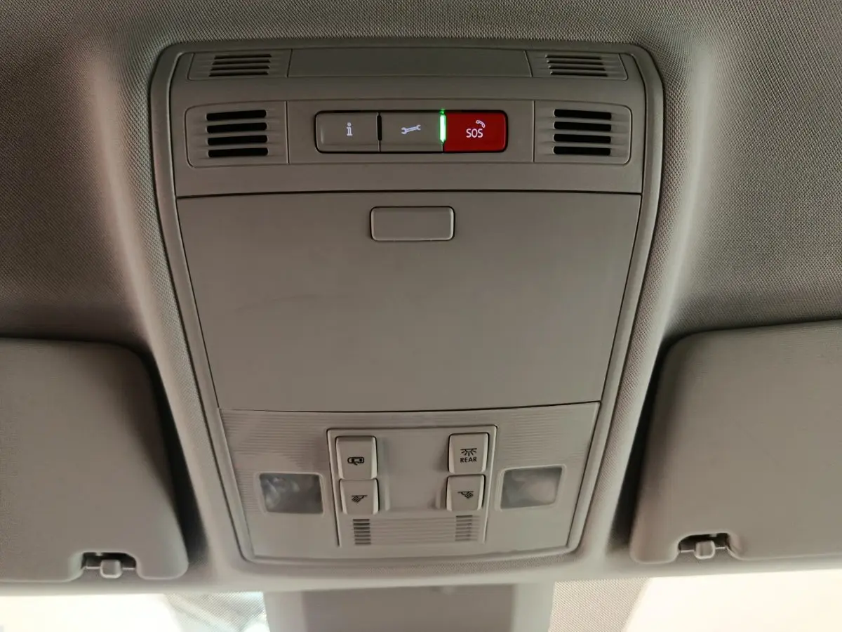 Vue en contre-plongée du panneau de commande de toit gris clair avec bouton SOS rouge dans un Skoda Kodiaq noir 2021