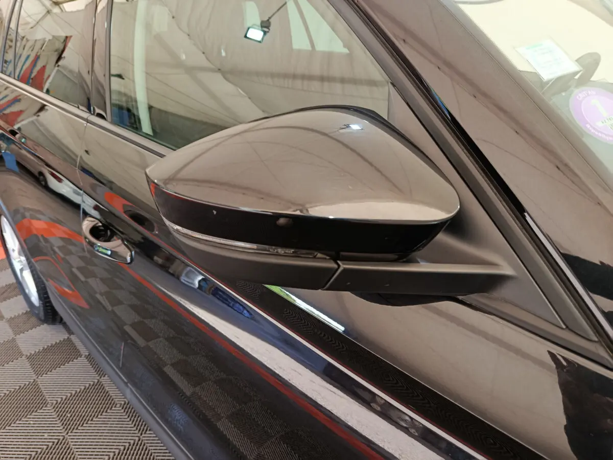 Rétroviseur côté gauche noir brillant du Skoda Kodiaq 2021, vue rapprochée sur la portière et la poignée.