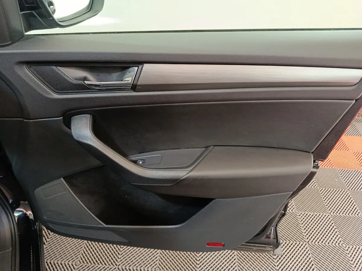 Vue rapprochée de la porte avant gauche noire du Skoda Kodiaq 2021 avec garniture noire et insert bois.