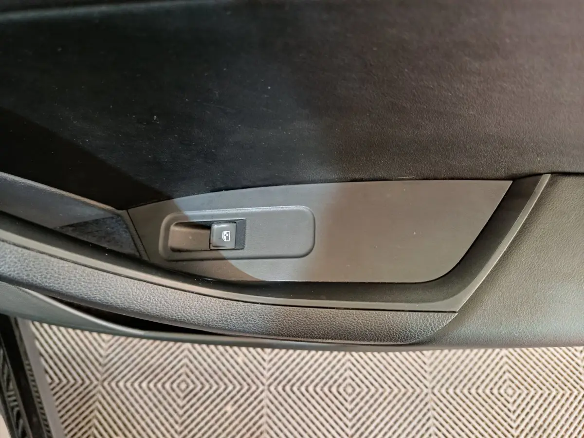 Gros plan sur le bouton de verrouillage centralisé côté gauche de la porte intérieure noire du Skoda Kodiaq 2021.