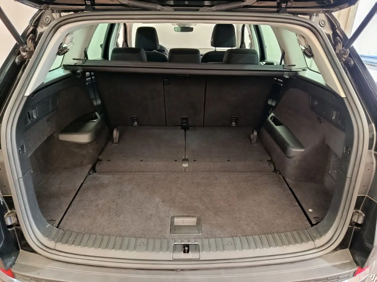 Coffre ouvert vue arrière d'un Skoda Kodiaq noir 2021 avec sièges rabattus et plancher plat.