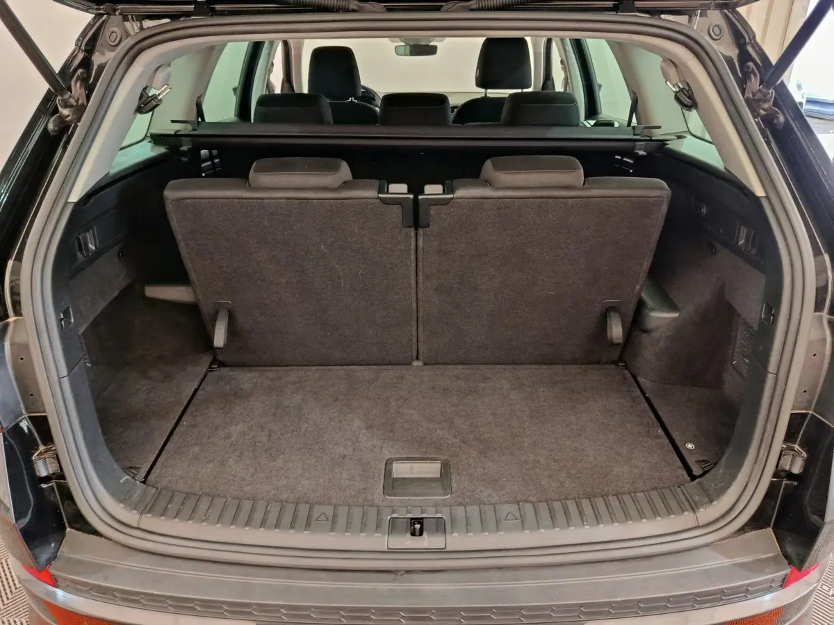 Coffre ouvert d'un Skoda Kodiaq noir 2021, montrant la 3ème rangée de sièges individuels et plancher plat.