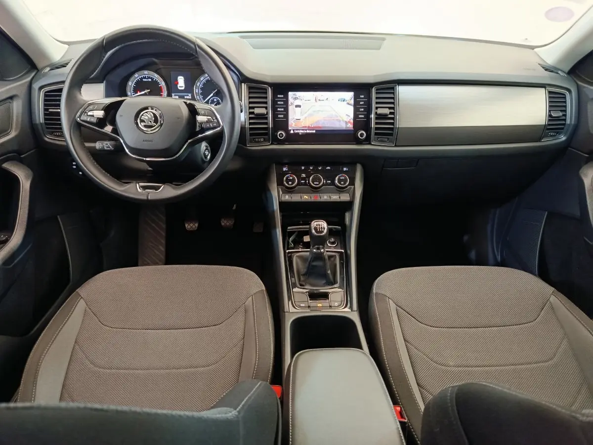 Intérieur du Skoda Kodiaq noir 2021, vue frontale du tableau de bord avec volant cuir et boîte manuelle.